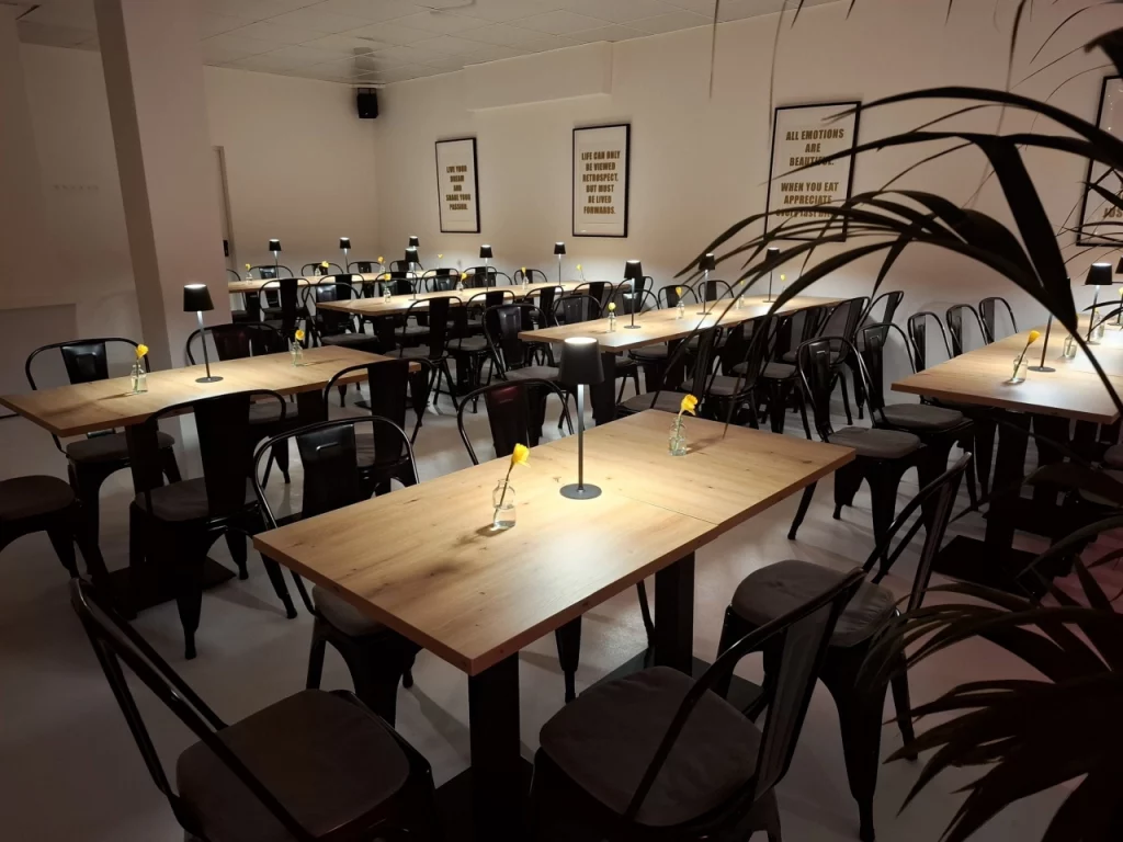 Eventlocation the we agency in Langenfeld: Bestuhlung mit Holztischen und moderner Beleuchtung für Team-Events.