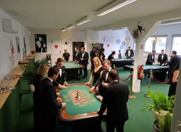 Modulare Eventlocation verwandelt in ein Casino Royale mit Roulette-Tisch, Poker-Tischen und Gästen in Abendgarderobe.